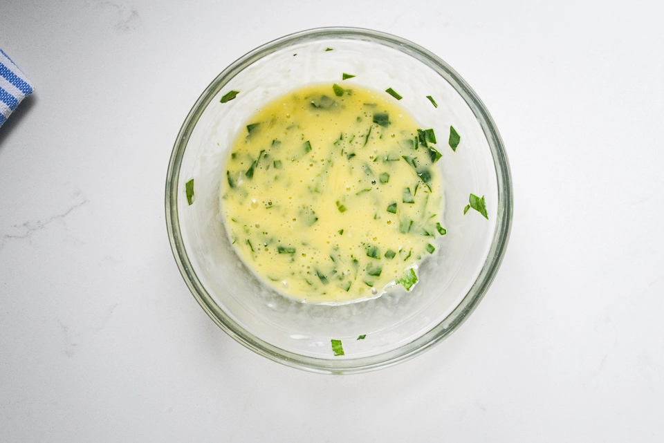 Whisked egg and spinach mixture for breakfast pizza.