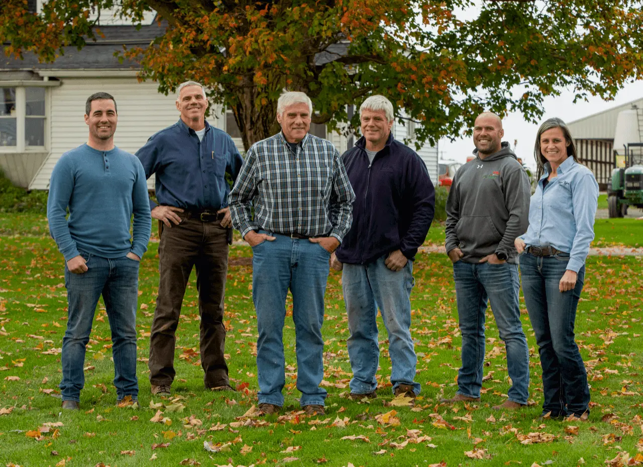 A family of 6 pose for a photo on their dairy farm.