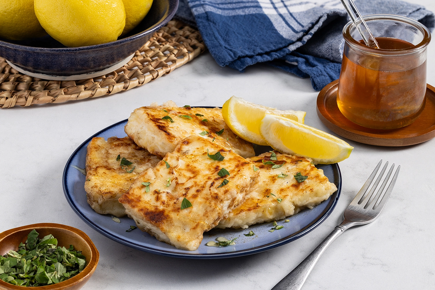 Fried saganaki cheese on a serving plate, garnished with oregano and drizzled with honey.