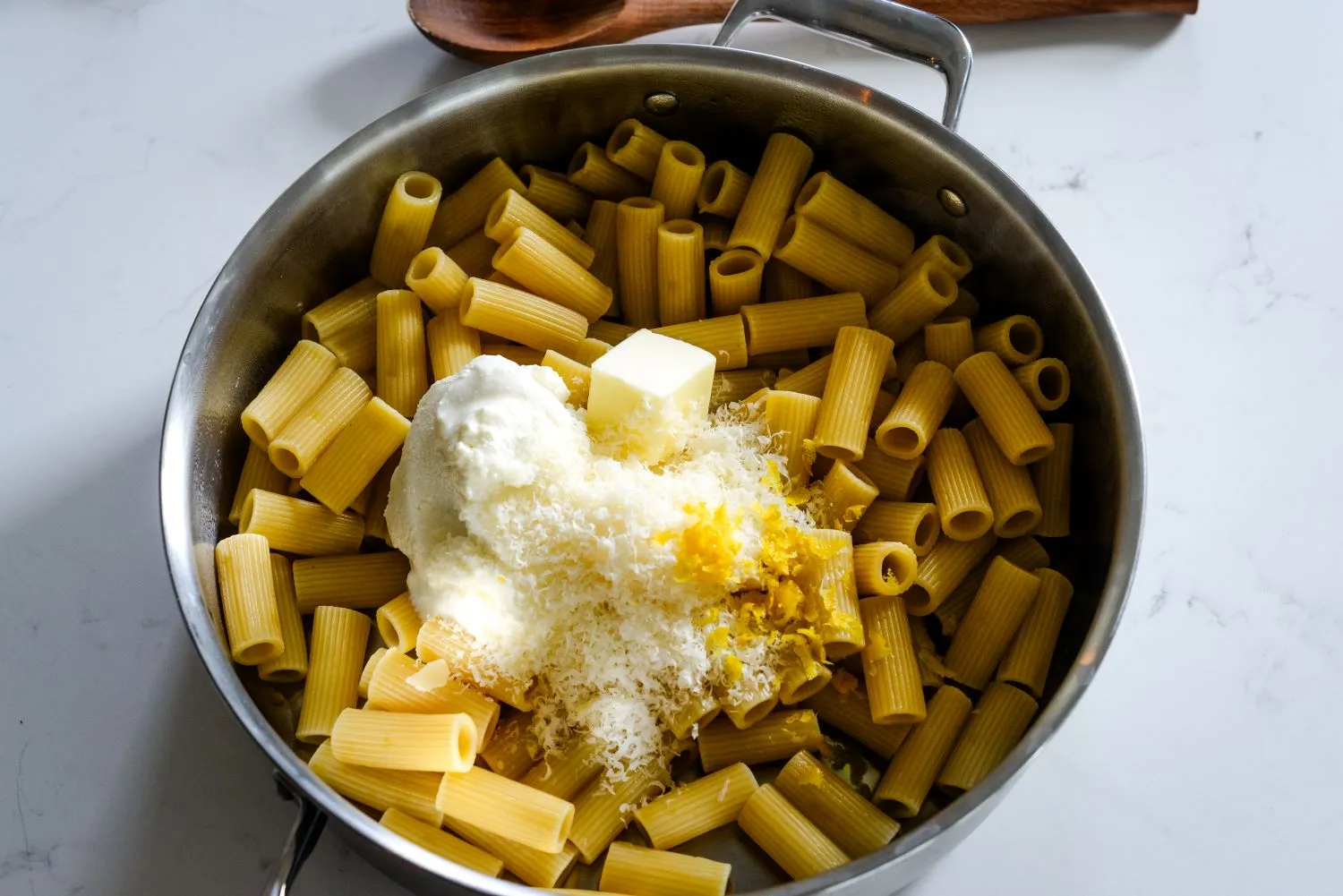 Cooked pasta topped with butter and Parmesan cheese